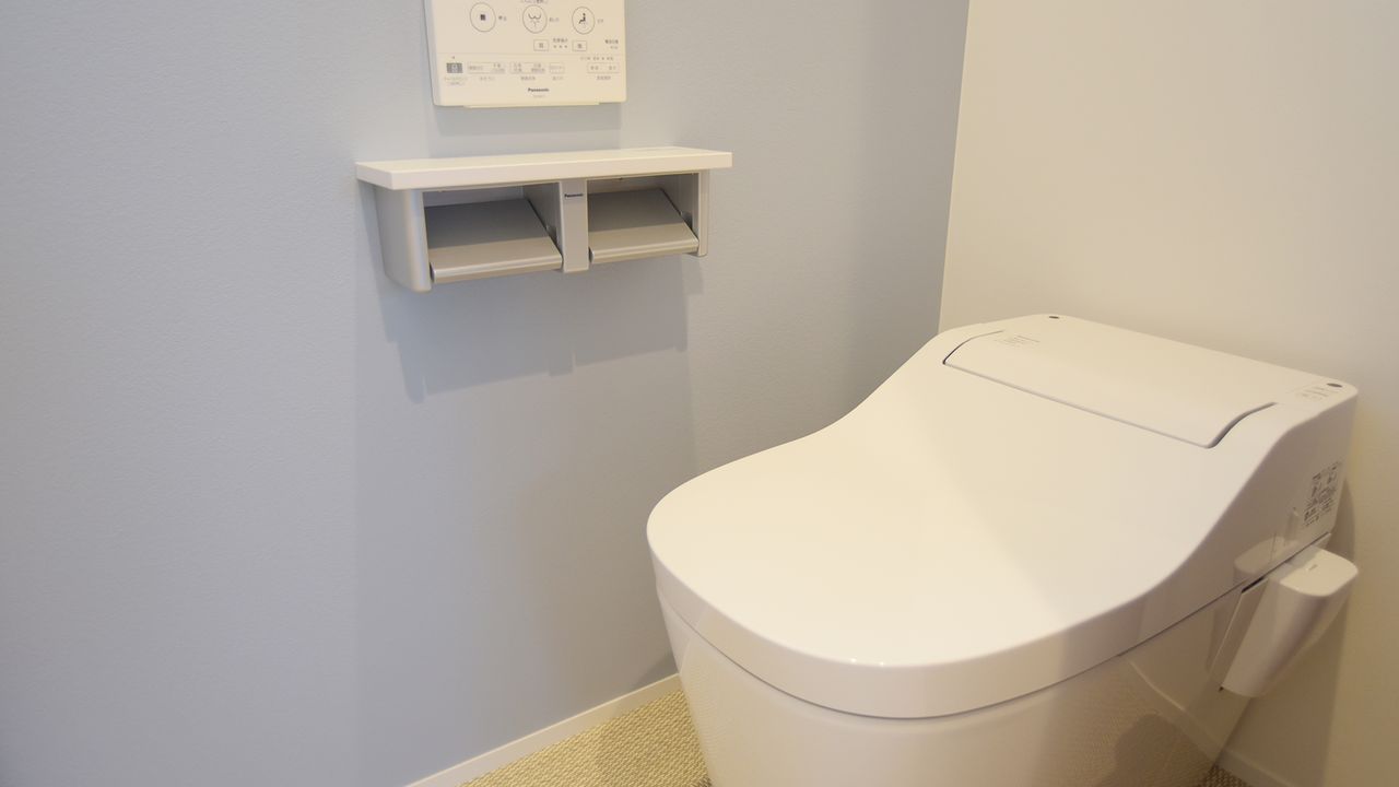 淡いブルーの壁紙で、やわらかい印象のトイレに