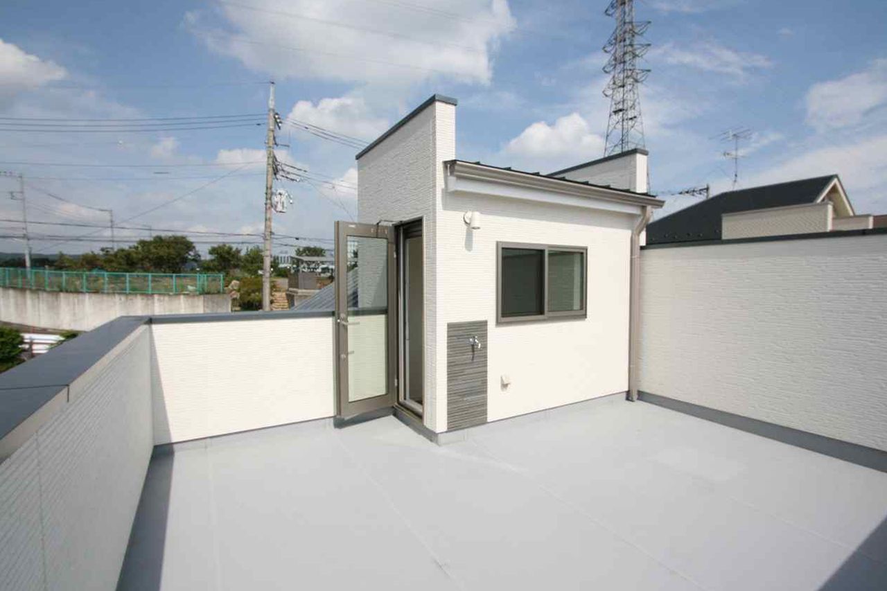 塔屋のドアから出入りする屋上、まわりを白い壁で囲みました