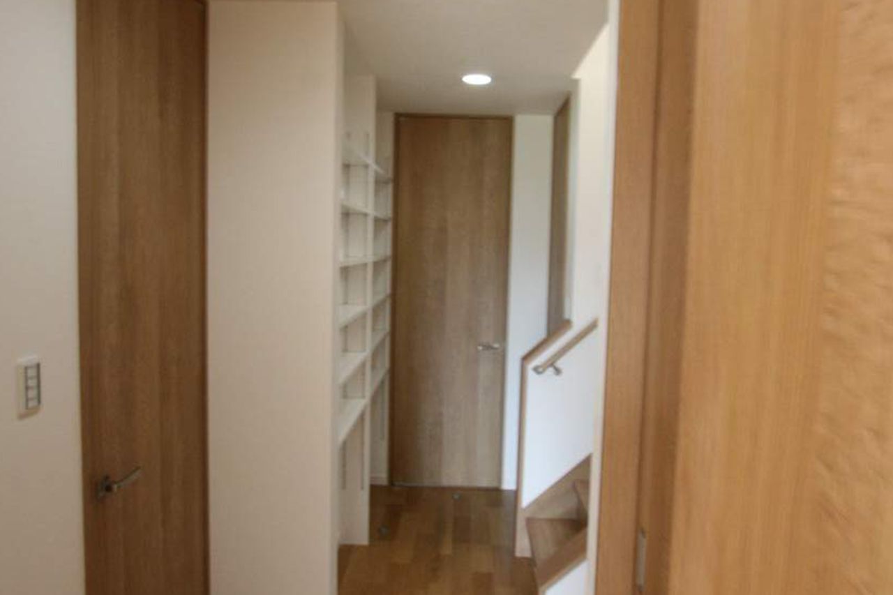 廊下の一角に棚を造り付け、通路を収納に生かしています