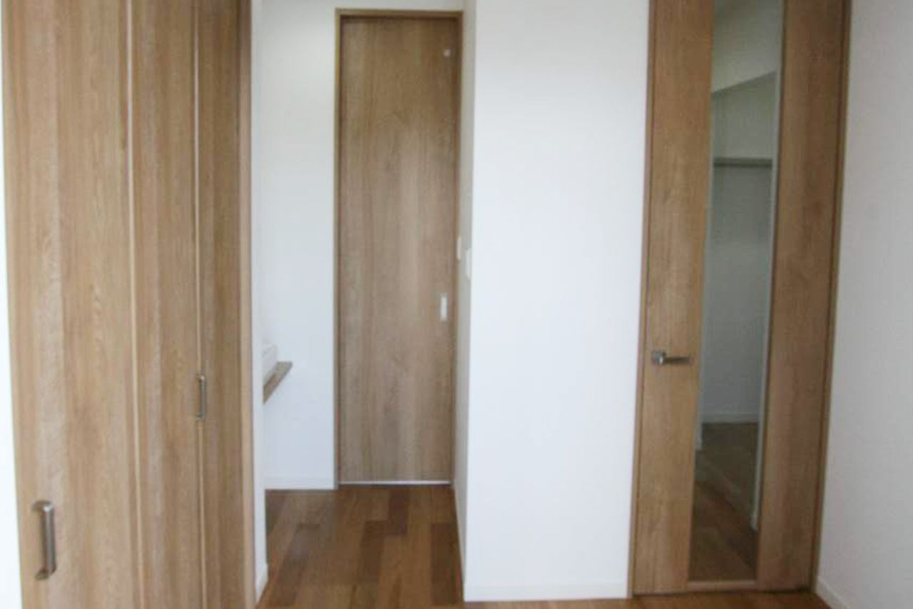 木目の建具でそろえた廊下、ドアのスリットから奥が見えます