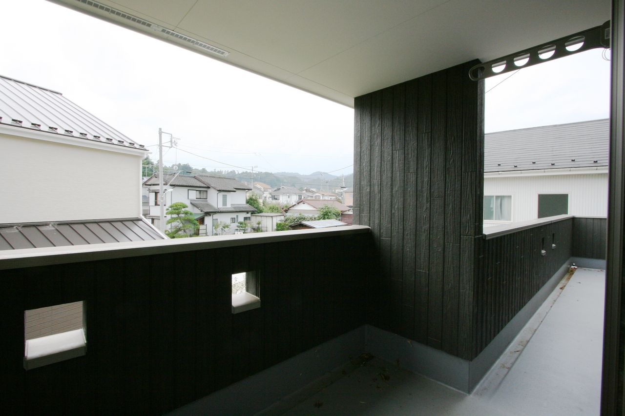 黒い板張りの壁で囲んだバルコニー、物干し金物も用意
