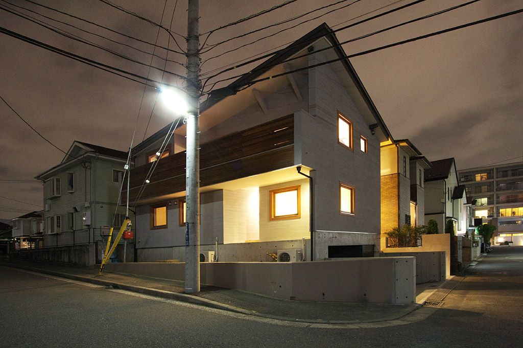 夜の外観、板張りのバルコニーと窓明かりがやわらかく映える
