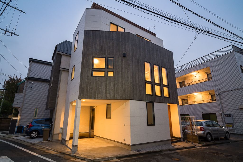 夕暮れの外観、並んだ窓の明かりが外壁の木目を引き立てます