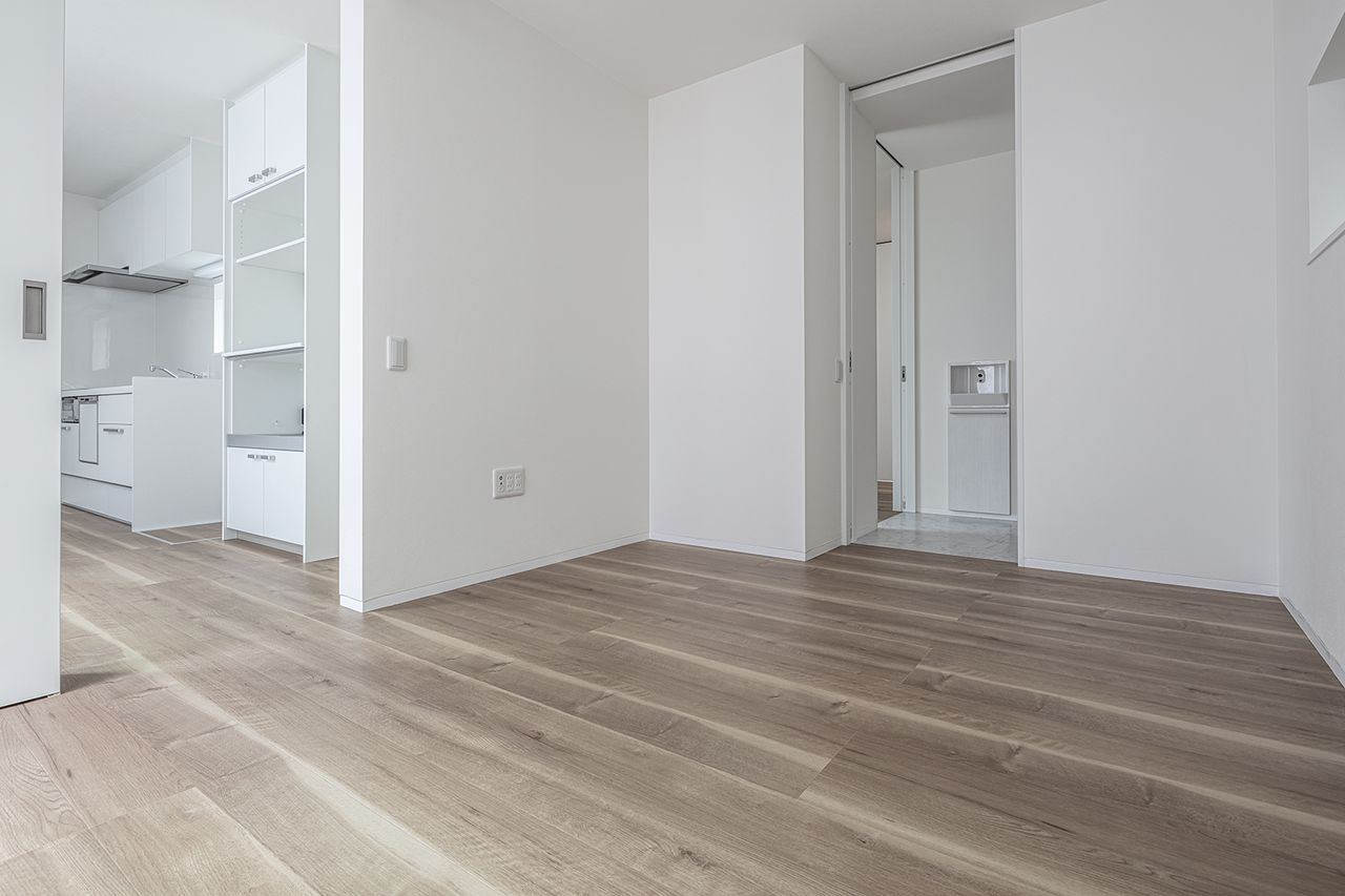 白い壁と建具でまとめ、淡い木目の床がやわらかさを添える