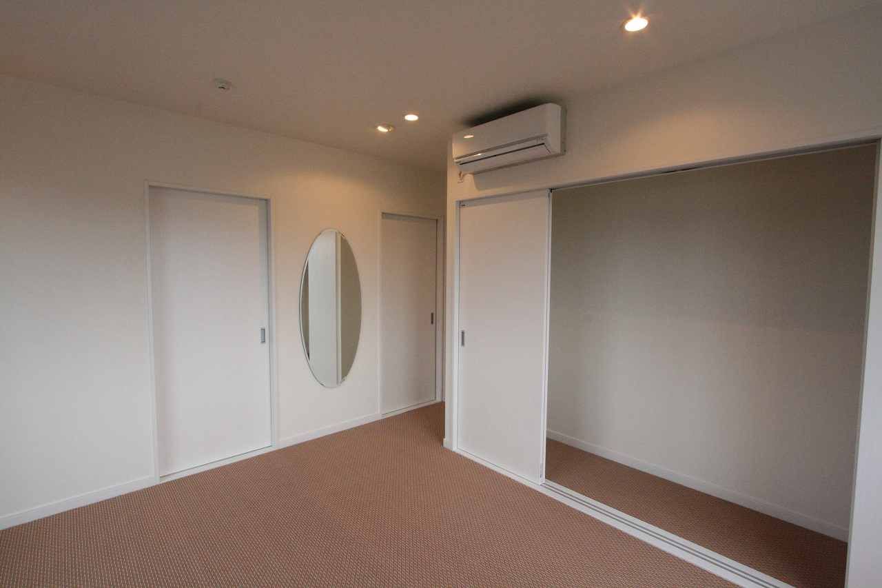 楕円の鏡を壁に据え、引き戸の収納を広く取っています